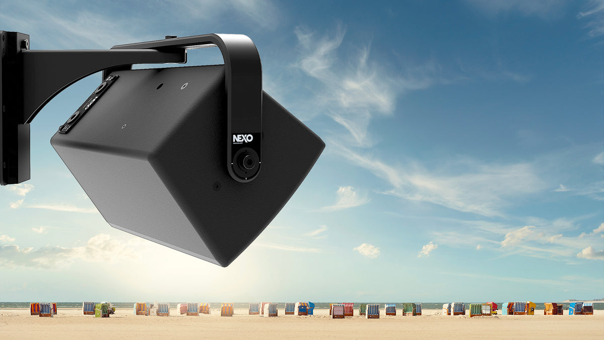 NEXO ePS outdoor speaker on a wall bracket in bright sunshine at a beach, illustrating UV resistance
